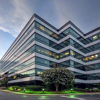 A glass-fronted commercial office building at dusk